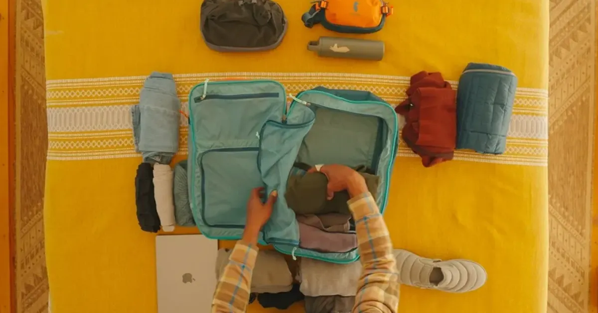 Open suitcase packed on a yellow field — the object a returns portal is written for