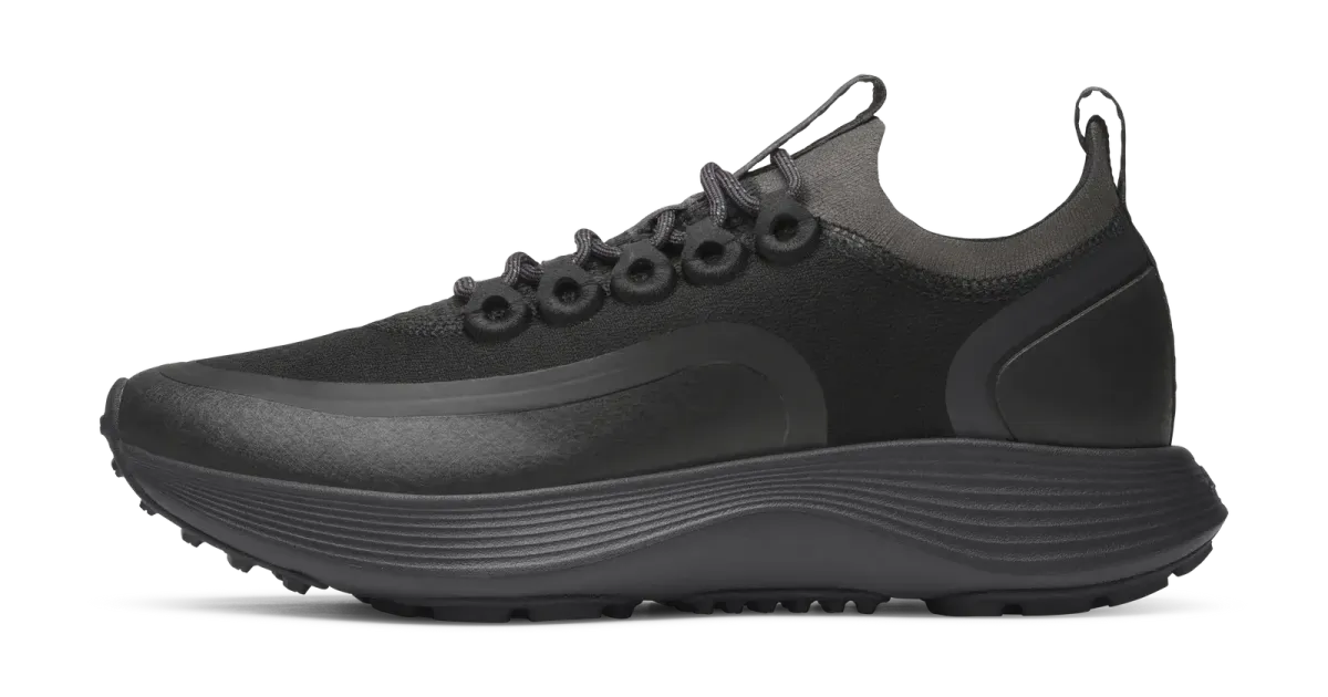 Allbirds runner photographed in profile on a dark field