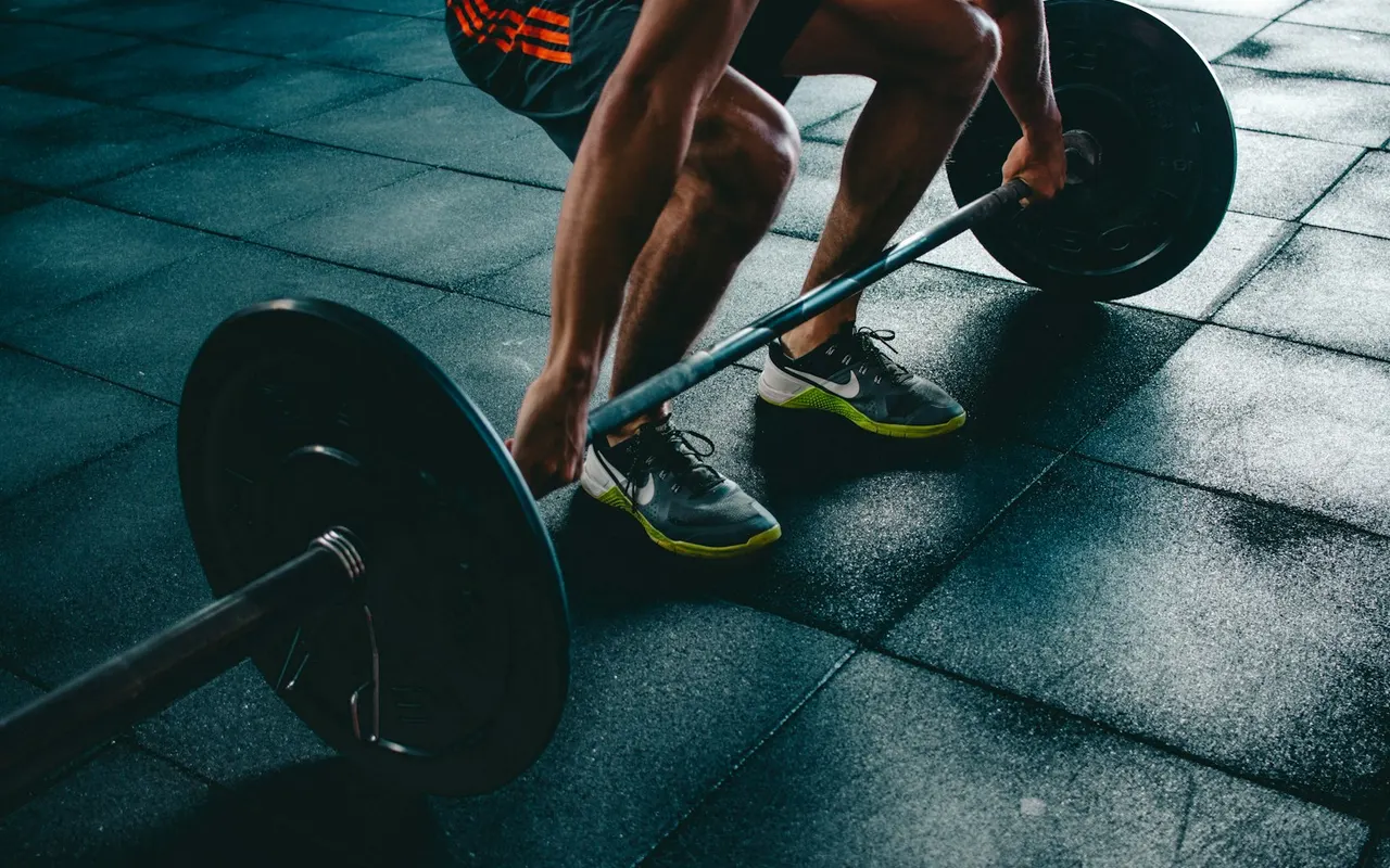 Lifter setting up a barbell on a gym floor
