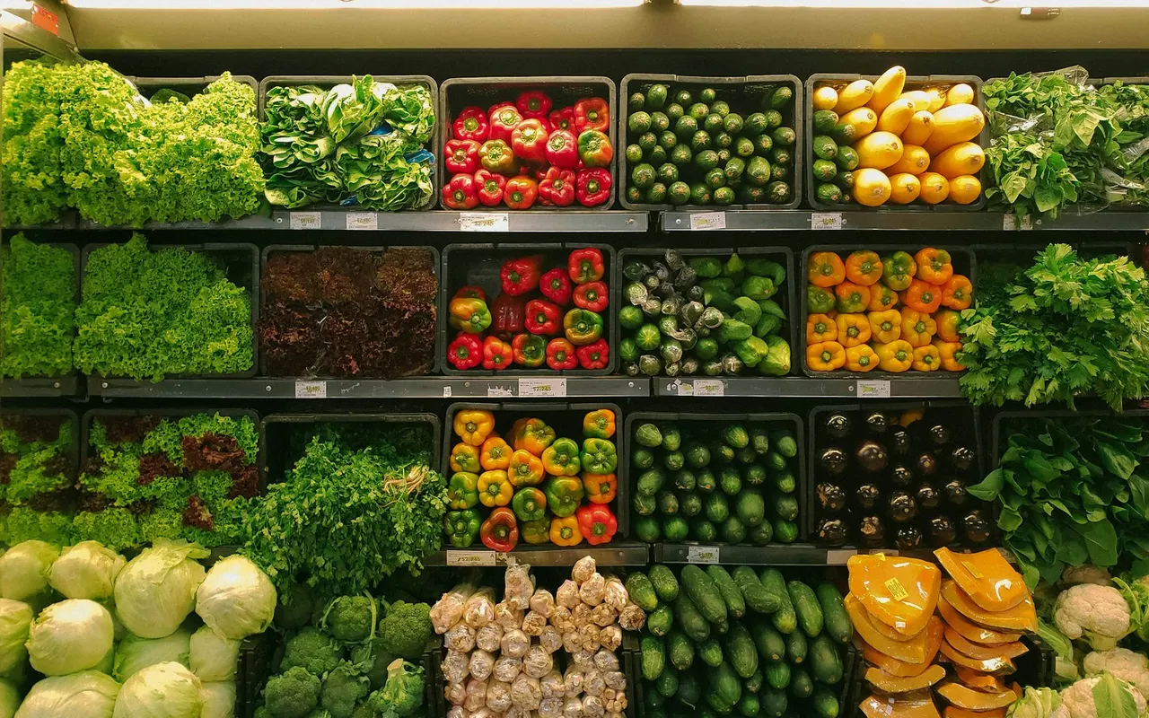 Grocery produce wall with peppers, greens, and boxed vegetables