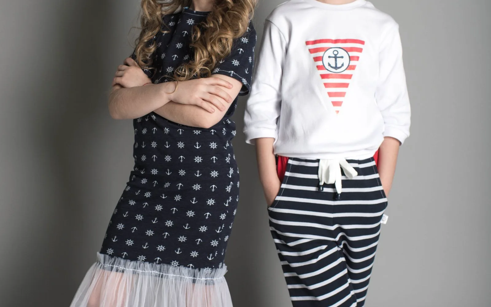 Two kids wearing navy and stripe knit sets
