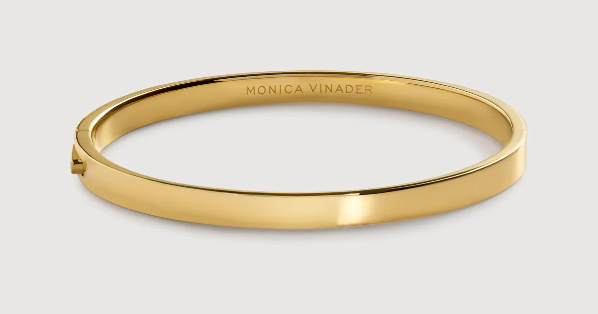 Monica Vinader gold vermeil bangle photographed on a neutral background