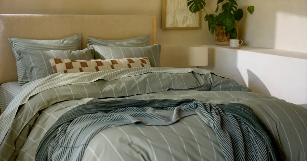 Striped duvet on a made bed — the object a returns table is written for